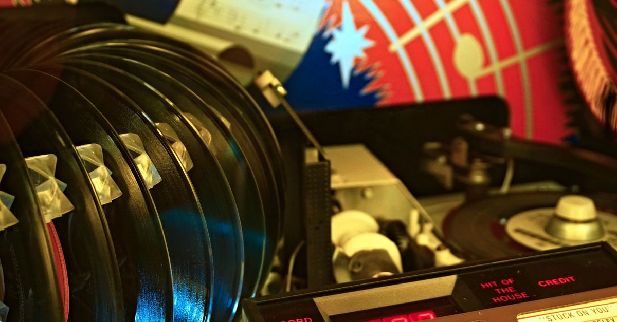 Close-up of a retro jukebox featuring vinyl records and classic hits playing in a vibrant setting.